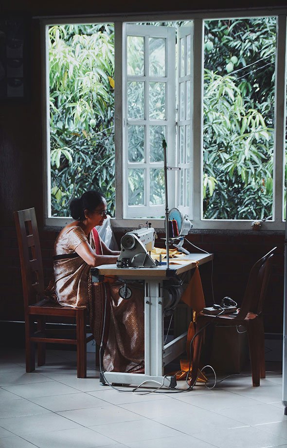 mujer cosiendo con la ventana abierta