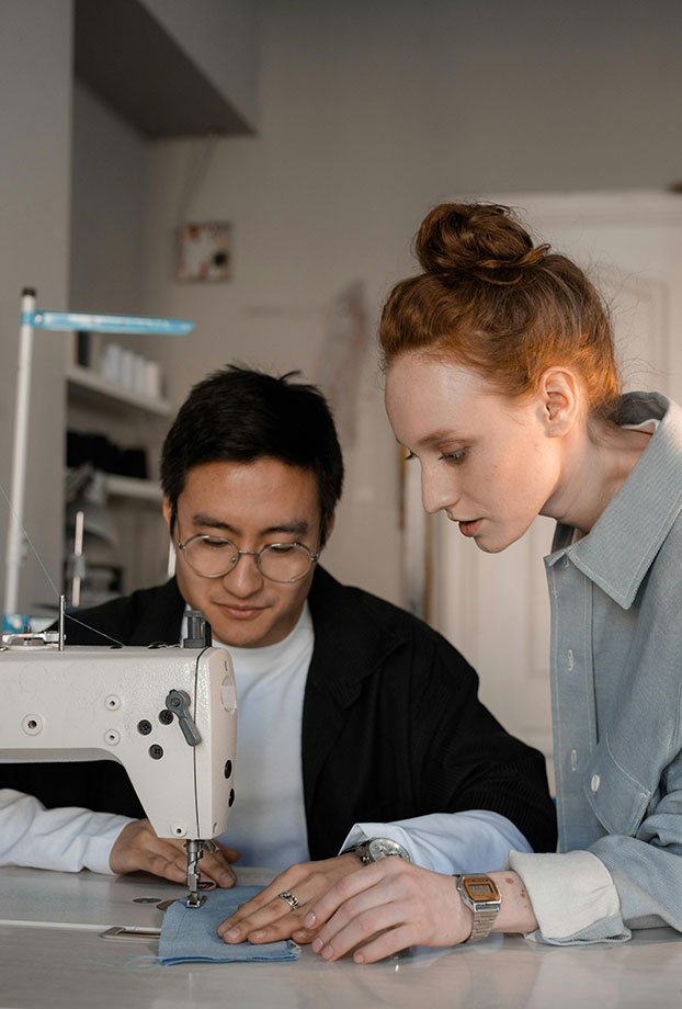 hombre y mujer confeccionando en maquina de coser