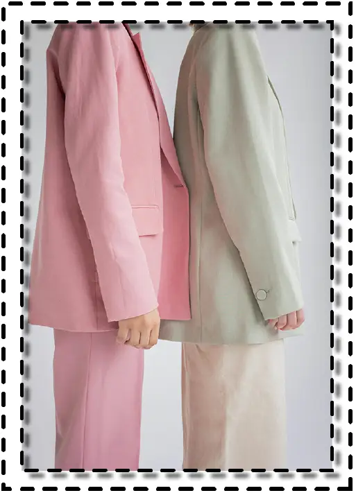 Vista lateral de dos personas usando trajes monocromáticos en tonos pastel, rosa y verde menta.