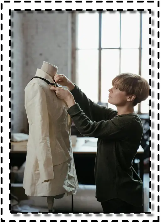 Diseñadora de moda trabajando en un maniquí dentro de un taller luminoso.