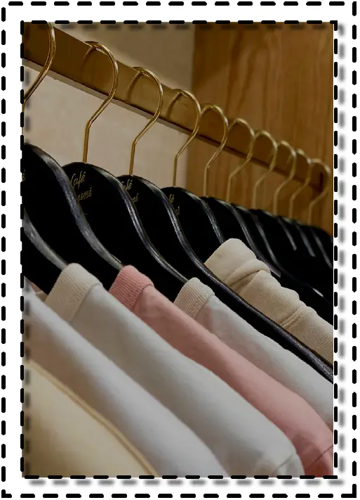 Ropa colgada en perchas de dorado metálico, vista de prendas terminadas en un showroom de moda